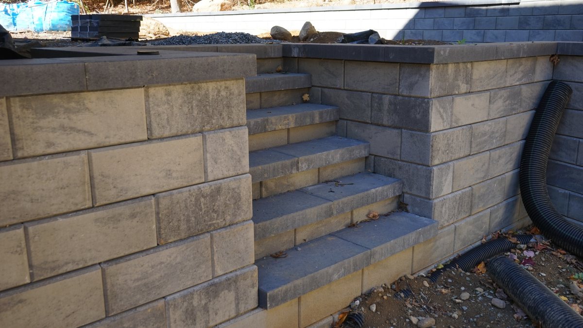 Completed block retaining wall and stair installation by RMR & Brothers